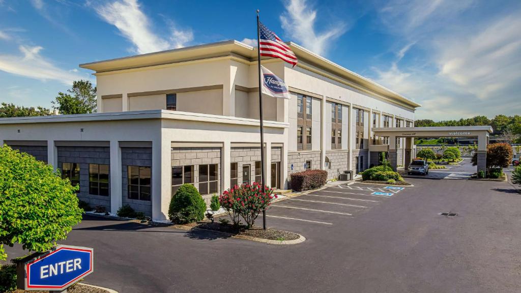 una vista exterior de un edificio de oficinas con una bandera americana en Hampton Inn Dickson, en Dickson