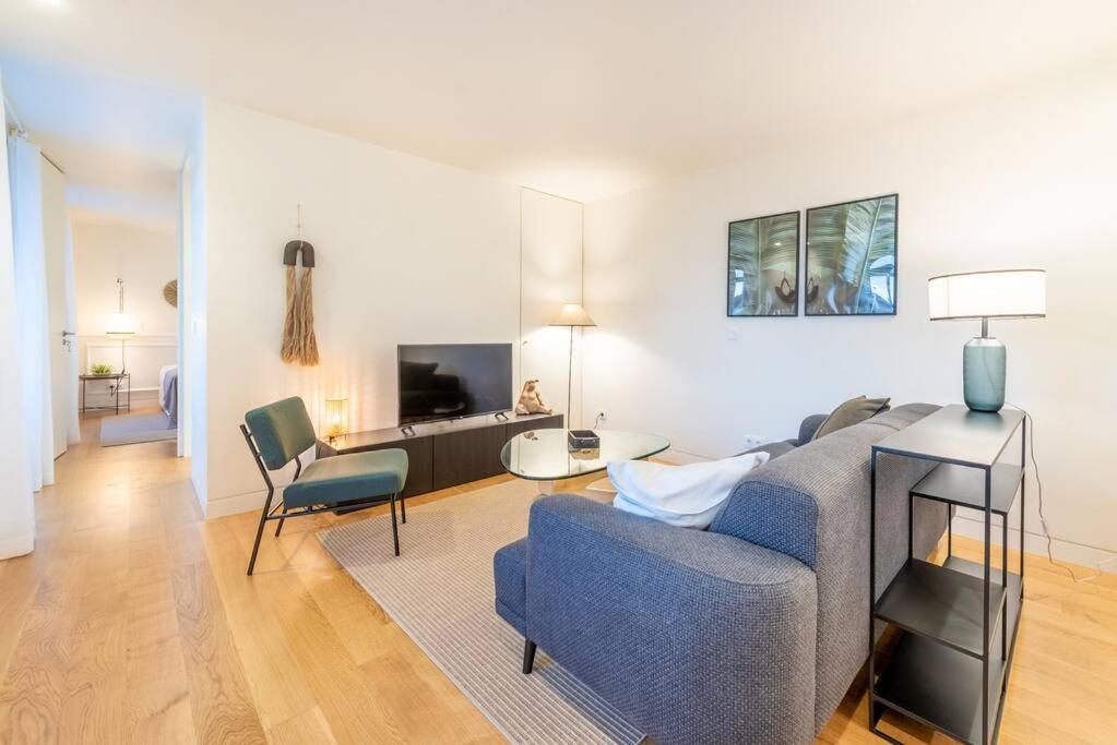 a living room with a blue couch and a table at GuestReady - Conde das Alcáçovas in Paço de Arcos