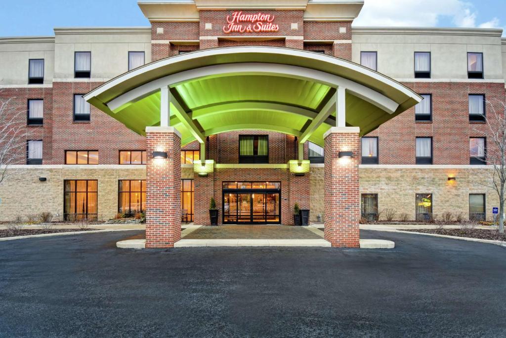 a hotel with a large building with a sign on it at Hampton Inn & Suites Detroit-Canton in Canton