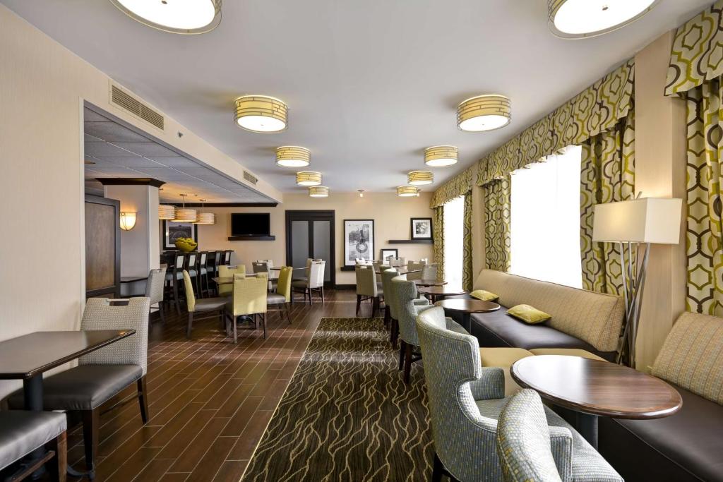 a restaurant with couches and tables and chairs at Hampton Inn Detroit Northville in Northville