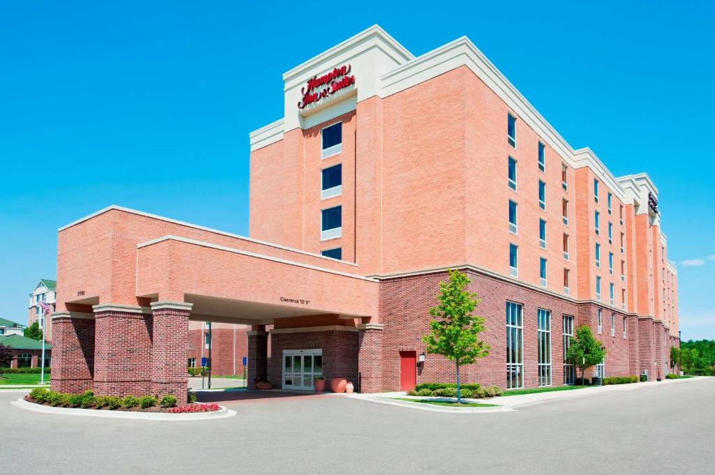 Hampton Inn & Suites Detroit/Airport Romulus في رومولوس: مبنى من الطوب الأحمر كبير مع فندق