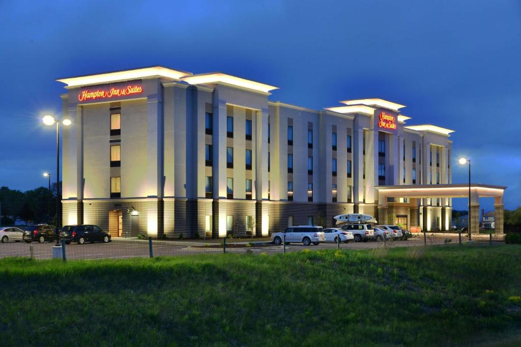 um edifício de hotel com carros estacionados em frente em Hampton Inn & Suites Chippewa Falls em Chippewa Falls