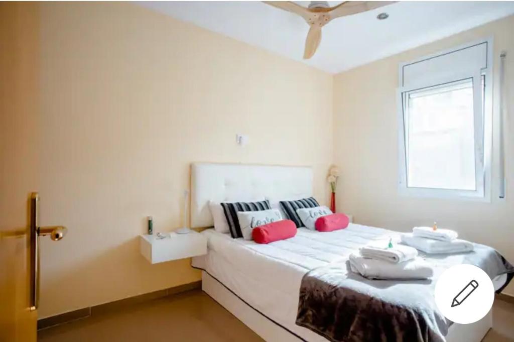 een slaapkamer met een groot wit bed met rode kussens bij BEAUTIFUL ROOM RIVER in Anglés