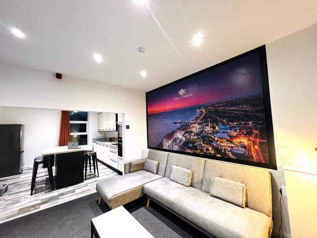 a living room with a couch and a large screen at The Pier Suite Serviced Apartment Blackpool in Blackpool