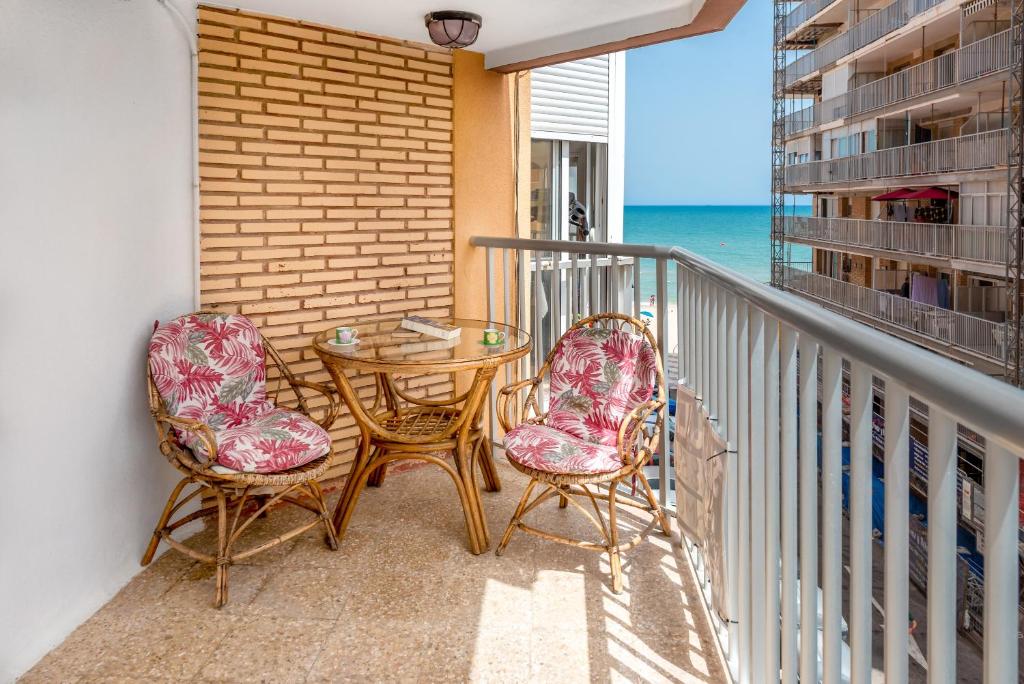 Un balcón con una mesa y dos sillas y el océano en View of the sea Beach 50 meters, en Sueca