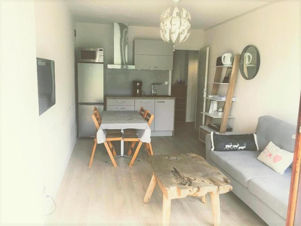 a living room with a table and a couch at Appartement Balcon Villard-de-lans in Villard-de-Lans
