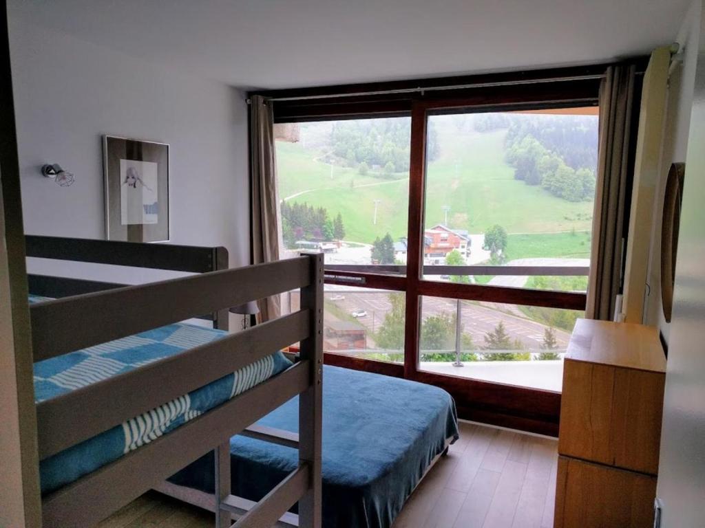 een slaapkamer met een stapelbed en een groot raam bij Appartement Balcon Villard-de-lans in Villard-de-Lans