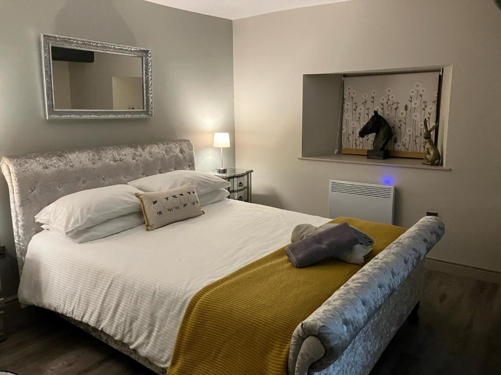 een slaapkamer met een groot wit bed en een spiegel bij ‘The Retreat” at the Rose @ Crown 