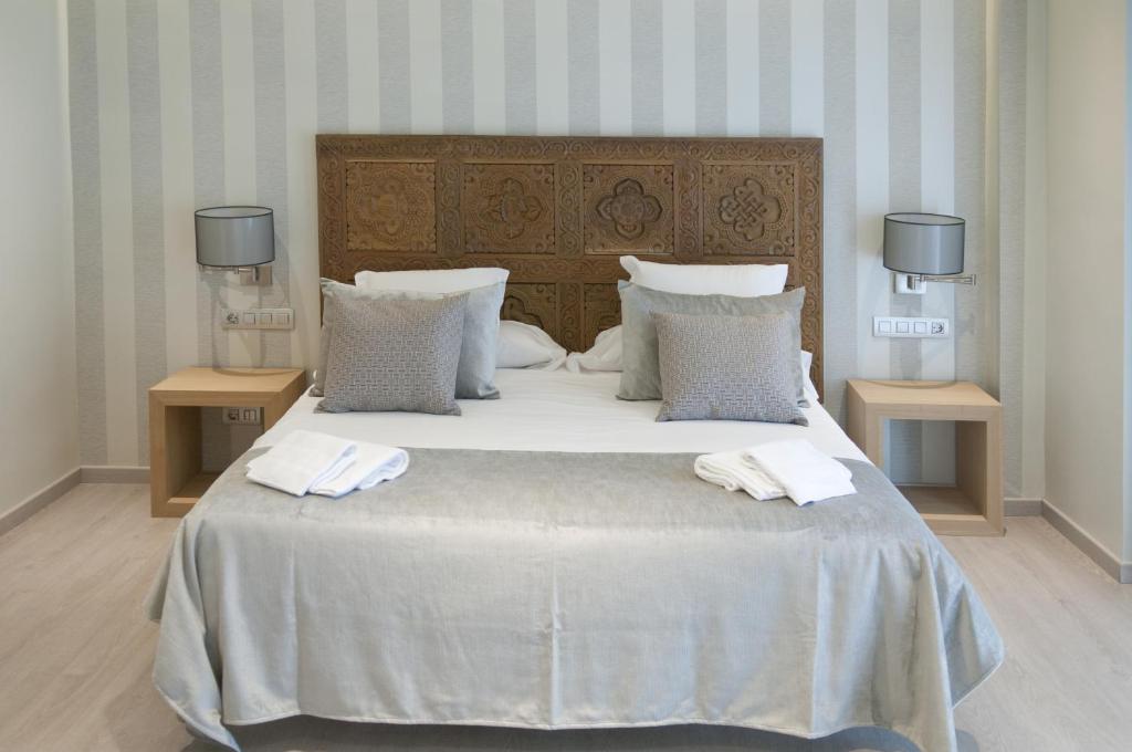 a bedroom with a large bed with two towels on it at Serennia Exclusive Rooms in Barcelona