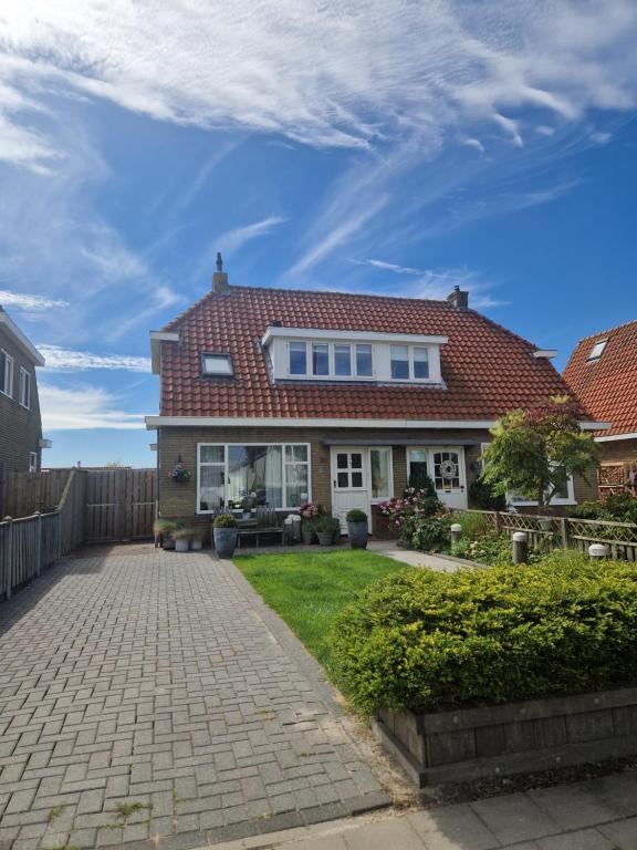 a house with a red roof and a brick driveway at Sfeervol huis nabij het centrum van Harlingen in Harlingen