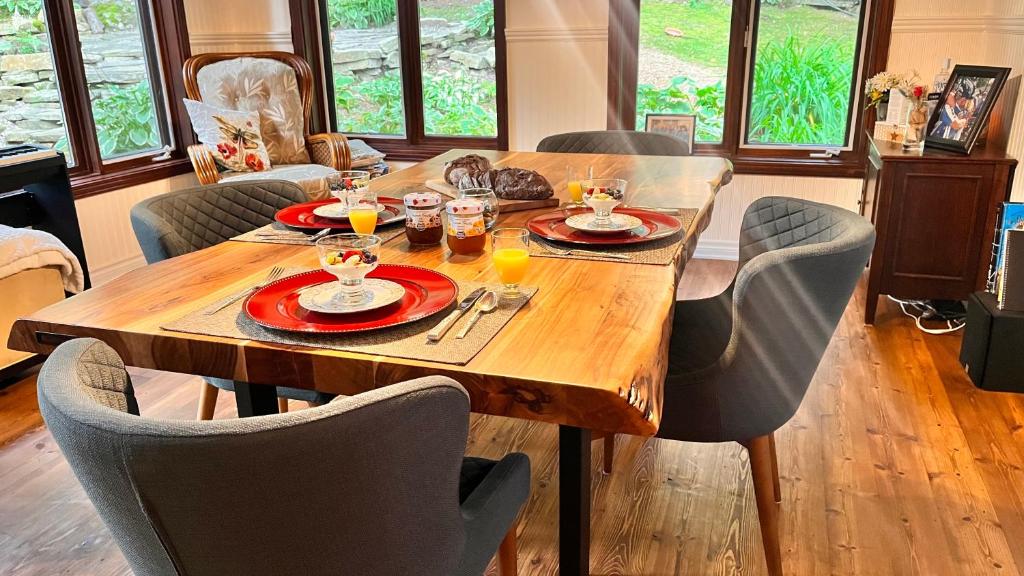 a wooden table with plates and drinks on it at PETIT COIN DE PARADIS in Sainte Anne des Lacs