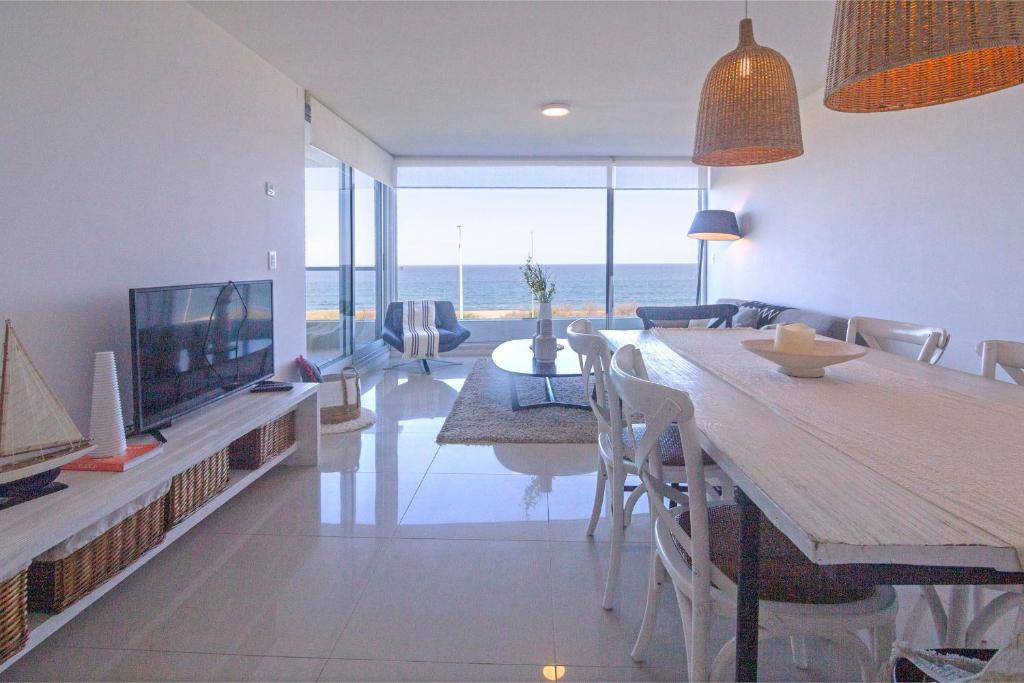 a living room with a dining room table with a view of the ocean at Oceana Suites Lumiere in Punta del Este