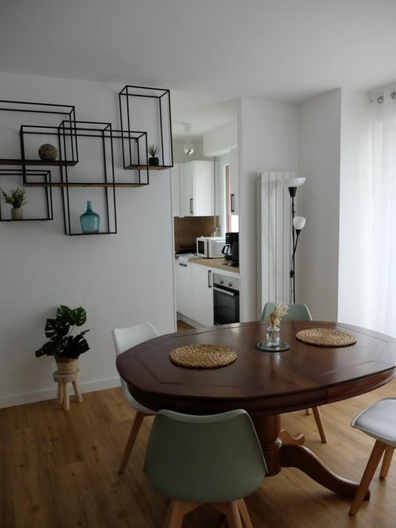 une table de salle à manger et des chaises dans une pièce dans l'établissement T2 à 150 M du centre-ville, parking privé, à Vannes
