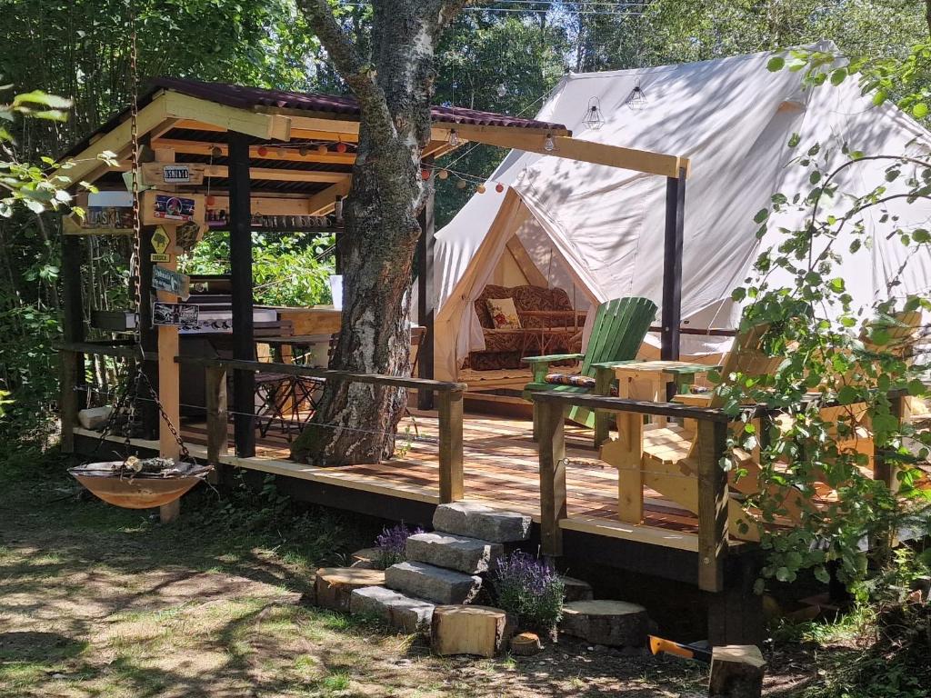 ein Zelt in einem Hof mit einem Baum in der Unterkunft Glamping Štôla- Symbioza in Štôla