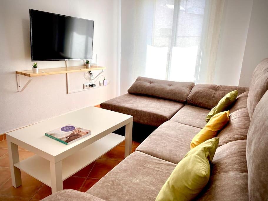 ein Wohnzimmer mit einem Sofa und einem Tisch in der Unterkunft MyChoice Dos Mares by Bossh! Apartments in Rota