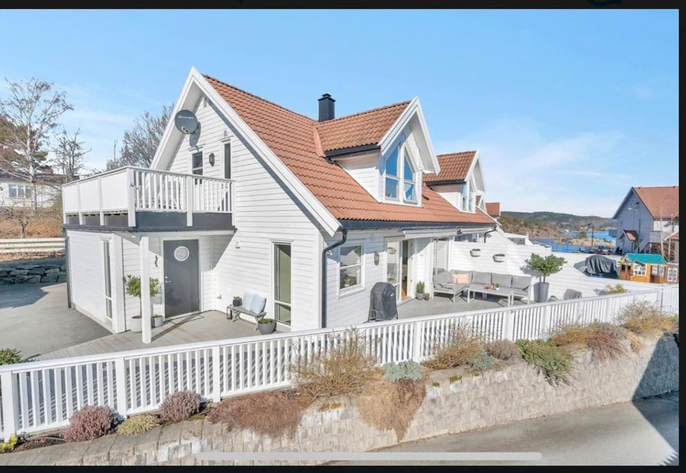una casa blanca con una valla blanca en Nydelig hus med utsikt en Kristiansand