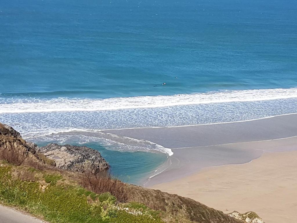 an aerial view of a beach and the ocean at Cellar Cove in Perranporth