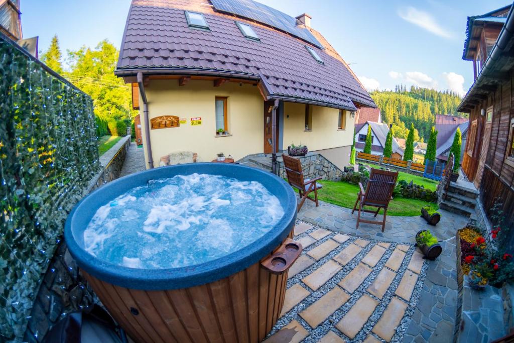 a hot tub in a large pot in a yard at Bylinkowa Chata Jacuzzi & Sauna in Poronin