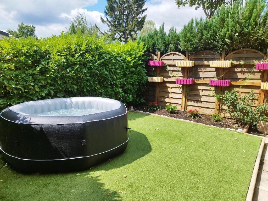 a hot tub on the grass in a garden at coin de paradis bord de Saone (avec jacuzzi) in Massieux
