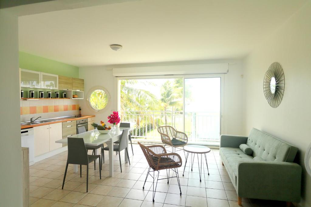 ein Wohnzimmer mit einem Sofa, einem Tisch und Stühlen in der Unterkunft Magnifique appt Crystal Beach in Saint-François