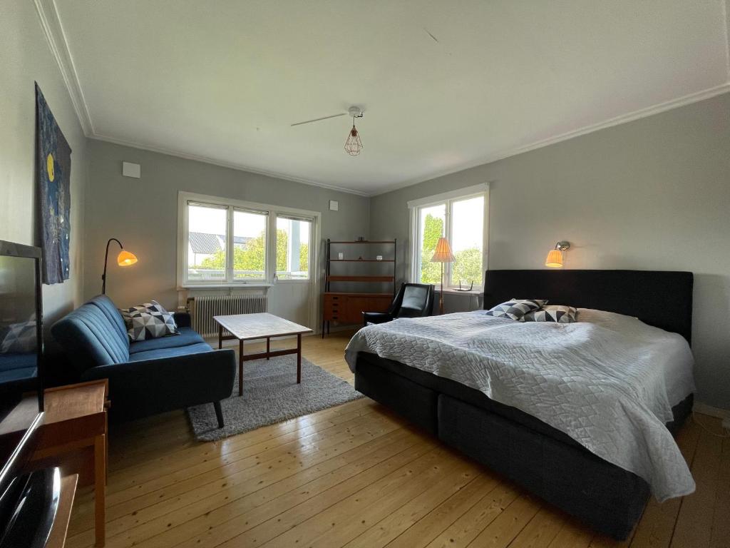 1 dormitorio con cama, sofá y mesa en Stor etta på lugna söder, en Växjö