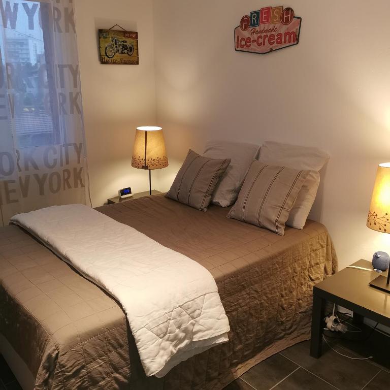 une chambre avec un lit avec deux lampes dessus dans l'établissement Maison 48m2 deux chambres cour privé et personnelle pour motos ou voitures 4 Pers proche mairie et bus tram, à Le Pont-de-Claix