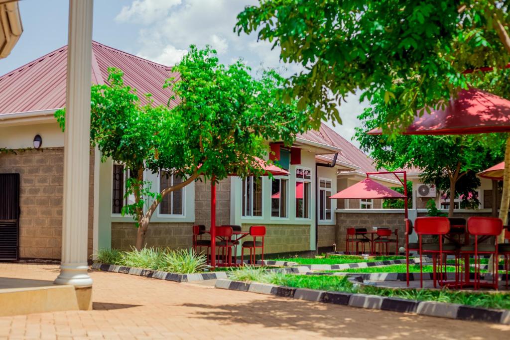 a building with red chairs and tables in front of it at Randa Cottages Moshi in Kirua
