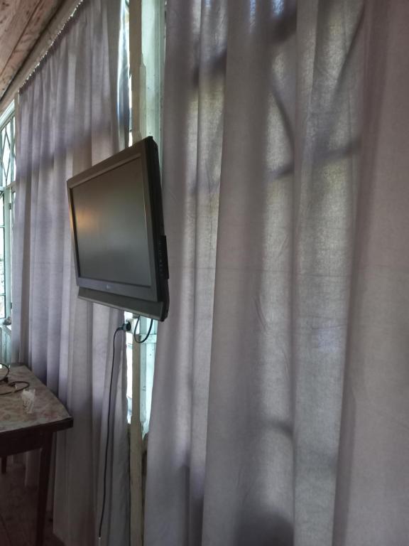 a tv sitting in front of a window with a curtain at Rusikos guest house in Oni