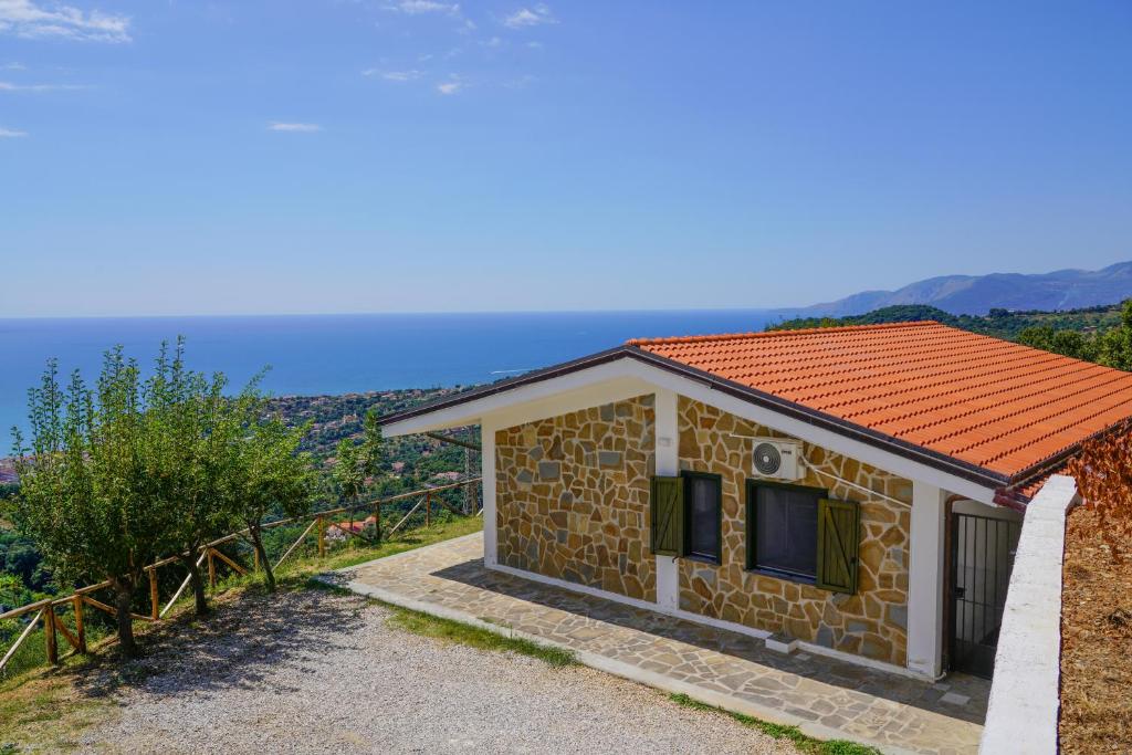 uma pequena casa de pedra com um telhado laranja em Villetta San Martino em Torraca