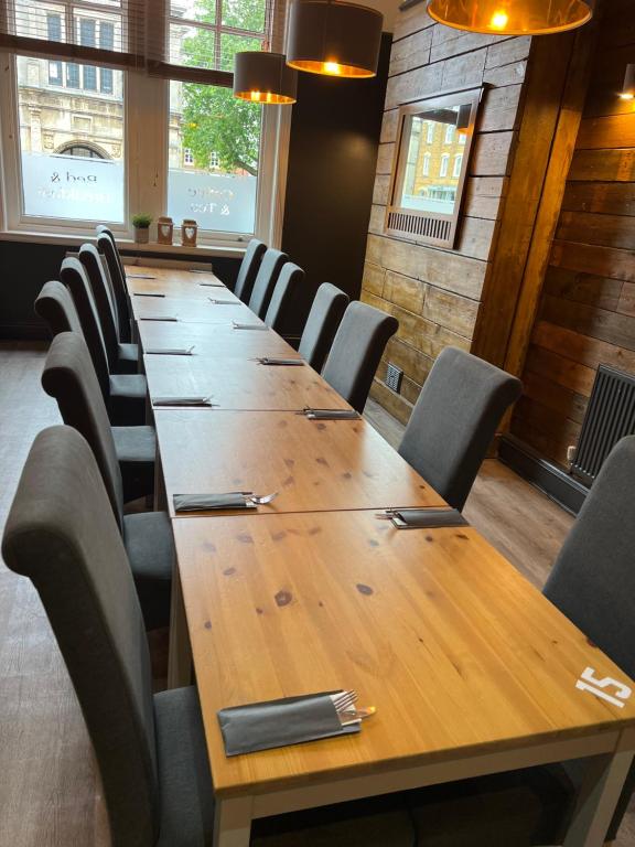 een lange houten tafel en stoelen in een kamer bij The Red Lion Inn in Rothwell