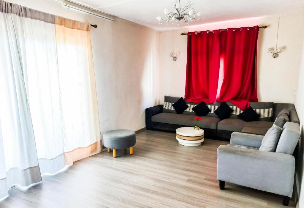 a living room with a couch and a red curtain at Residential House 3 Bedroom, 1 Bathroom Entire unit in Beau Bassin in Beau Bassin
