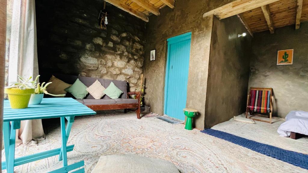 una camera con un tavolo blu e un divano di Hillhouse Hunza a Valle dell'Hunza