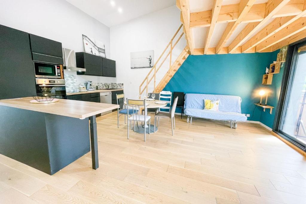 une cuisine et un salon avec une table et des chaises dans l'établissement #DQ Le Drac, à Saint-Égrève