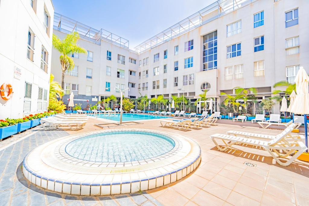 a courtyard with chairs and a pool in a building at El Secreto del Norte in Las Palmas de Gran Canaria