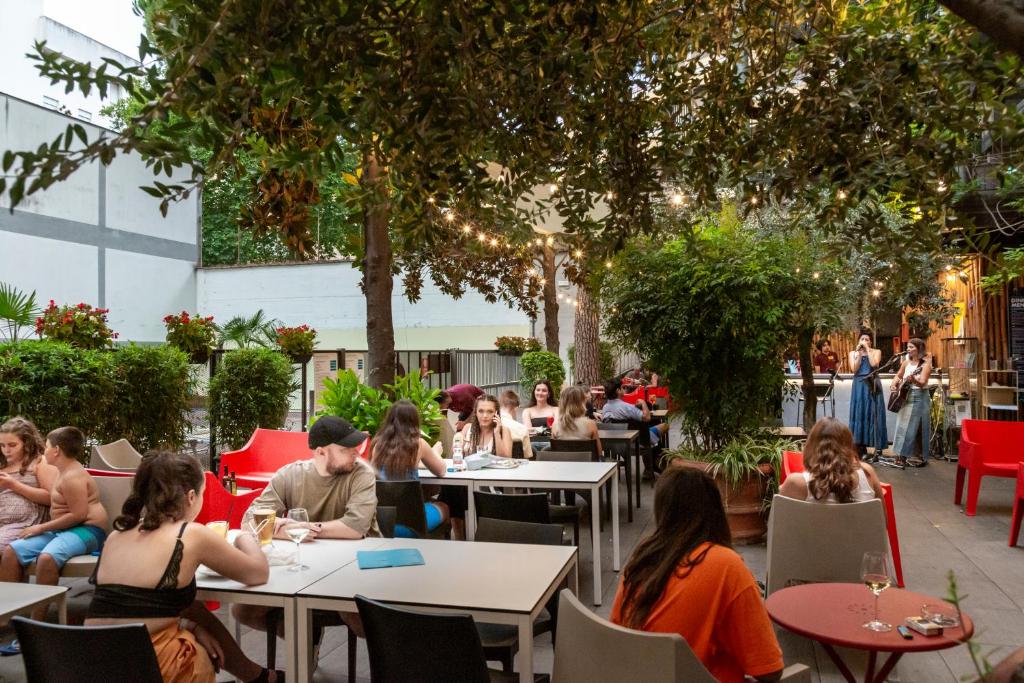 a group of people sitting at tables in a garden at Plus Florence in Florence
