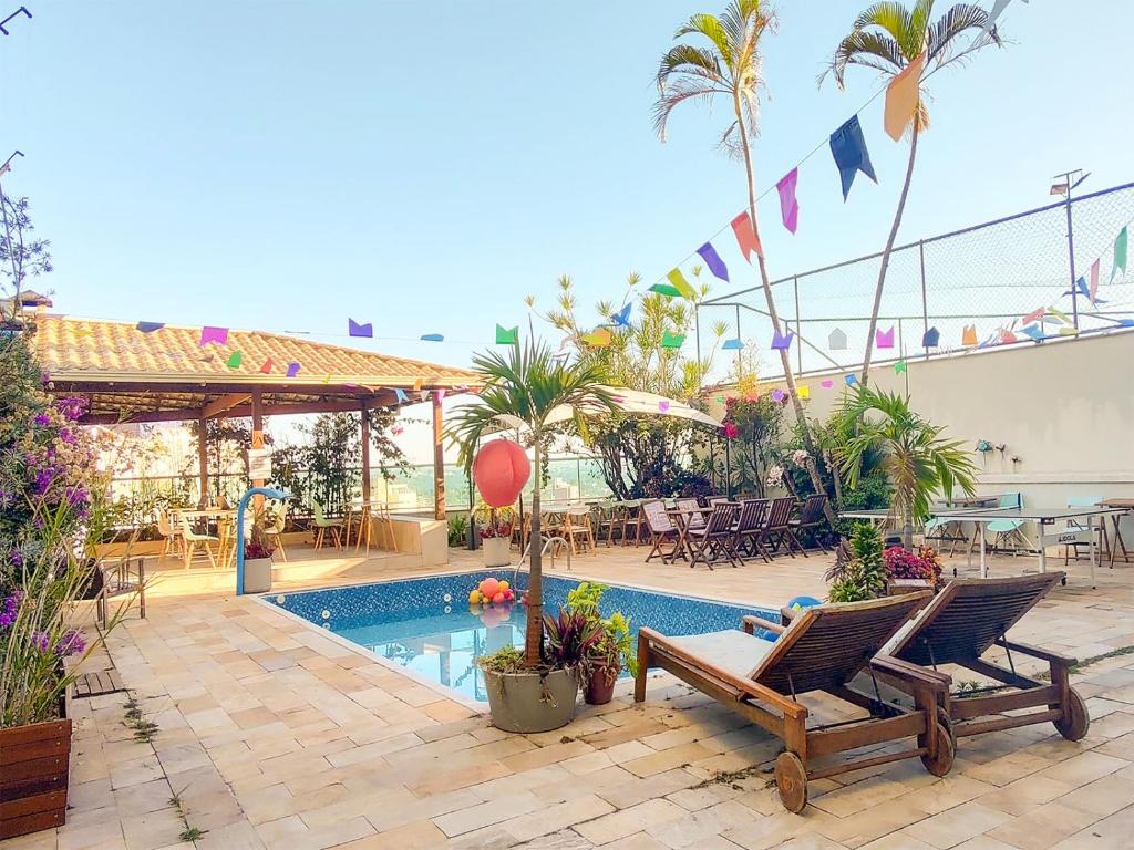a patio with two chairs and a swimming pool at Éden Pampulha - Hotel Coworking in Belo Horizonte