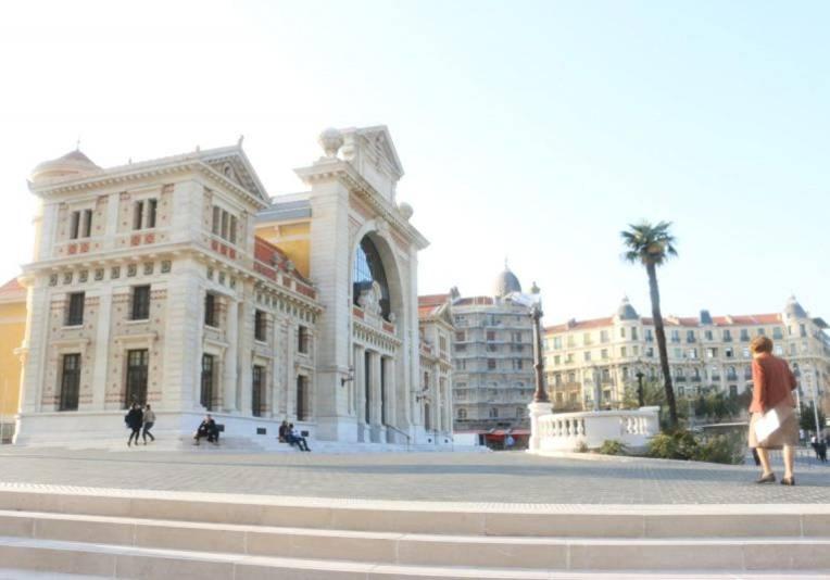 un homme debout devant un grand bâtiment dans l'établissement Hanna, à Nice