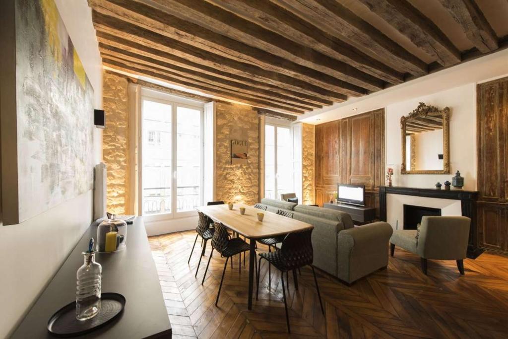 巴黎的住宿－Contrevents，客厅配有桌椅和壁炉