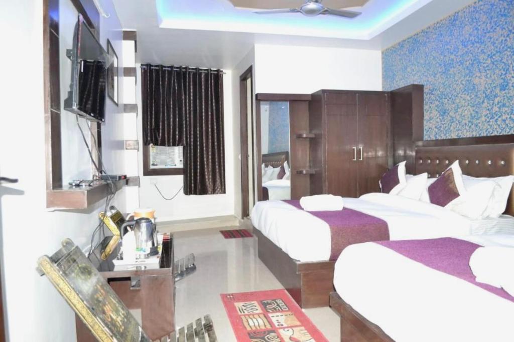 a hotel room with two beds and a television at Blossom residency By Dolphin 500 Mtr Taj mahal in Agra