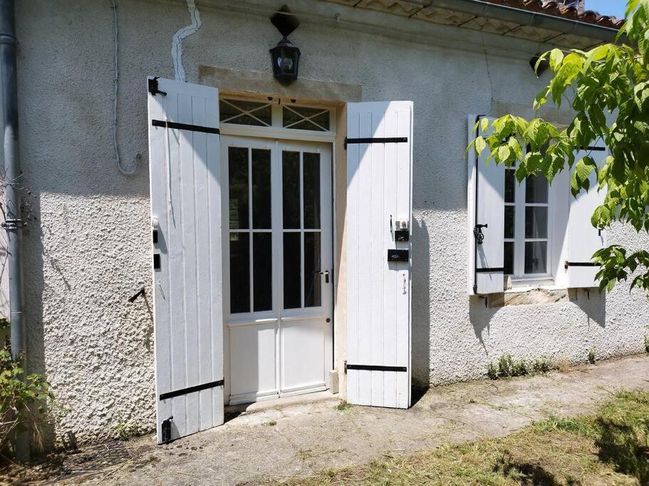 een witte deur en ramen op een gebouw bij Bienvenue en sud gironde in Villandraut