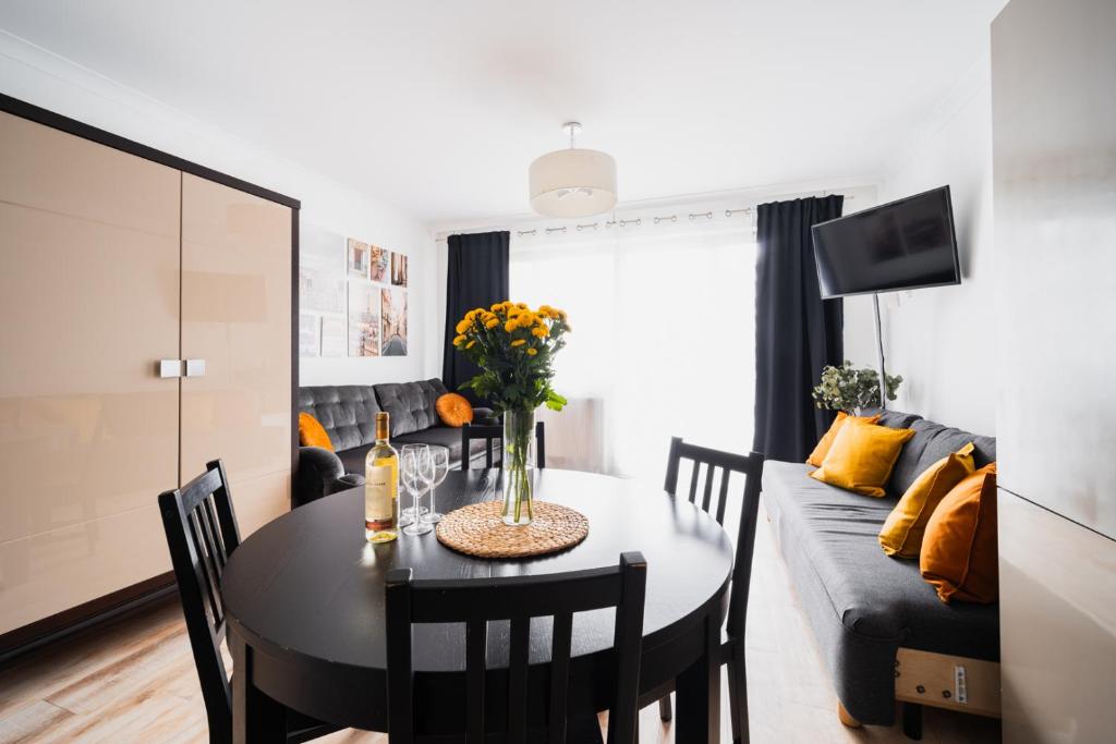 ein Esszimmer und ein Wohnzimmer mit einem Tisch und einem Sofa in der Unterkunft Apartment OLD TOWN - 3 Rooms - 2 Bathrooms - 12 People - Parking Place in Breslau