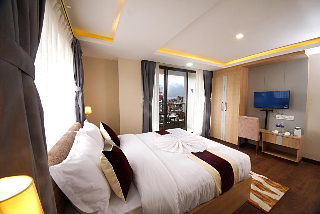 una camera d'albergo con un grande letto e una finestra di Divine Kathmandu Hotel a Kathmandu