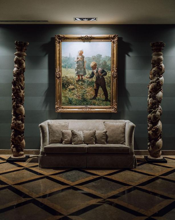 a couch in a room with a painting on the wall at Grande Real Villa Itália Hotel & Spa in Cascais