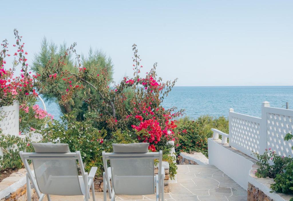 un balcón con sillas y flores y el océano en Villa Glaros, en Platis Yialos Sifnos
