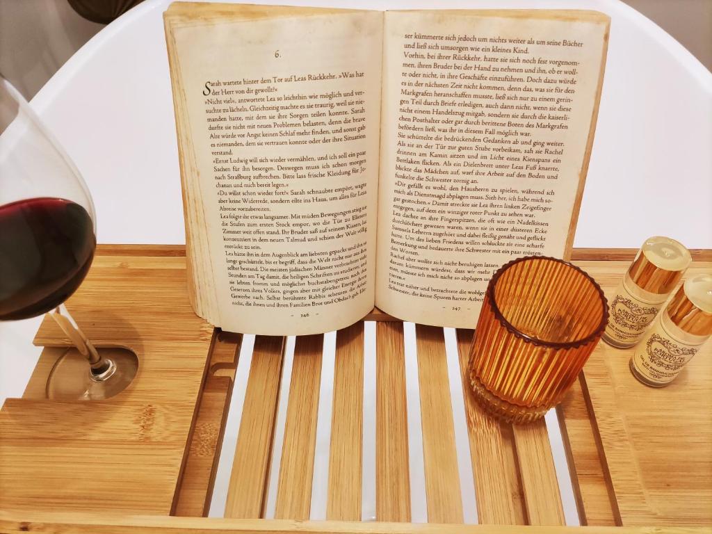 um livro aberto sobre uma mesa com um copo de vinho em stressfree charm house em Odeceixe