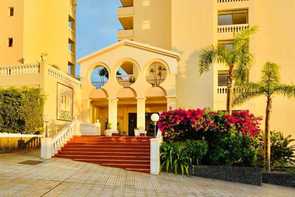 een gebouw met trappen en bloemen ervoor bij Apartamento Castle Harbour in Los Cristianos