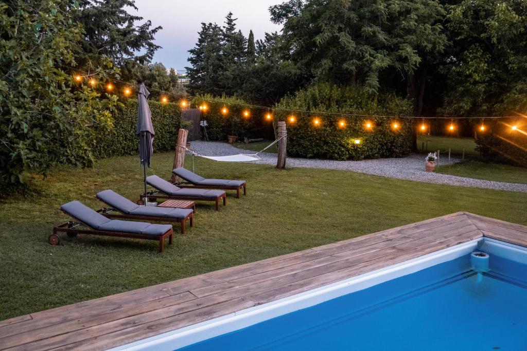 una fila de tumbonas junto a una piscina por la noche en CASENUOVE II - Casale con parco e piscina en Castiglioncello