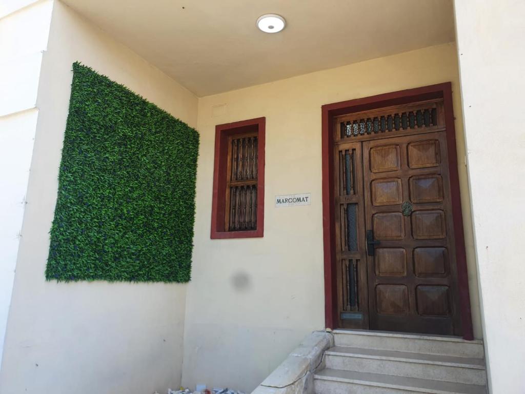 a building with a green wall next to a door at Ommi Hostel in St Julian's