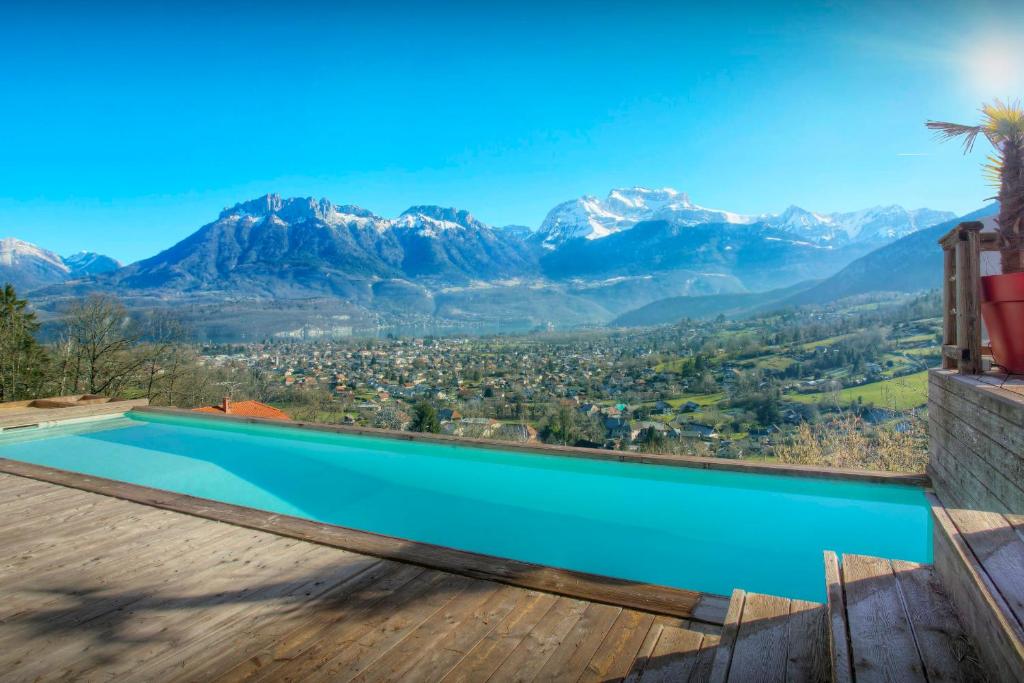 a swimming pool with mountains in the background at Chalet Kalyssia - OVO Network in Saint-Jorioz
