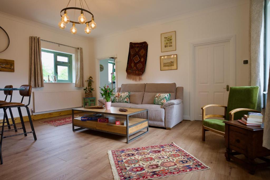 a living room with a couch and a table at Tring Grange Cottage in Wigginton